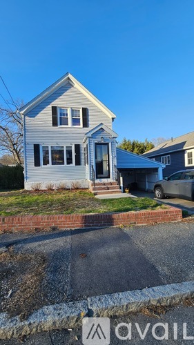 A house with a blue roof and white walls is for sale.