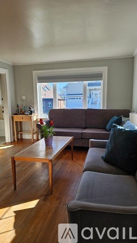 A living room with a grey couch and a wooden coffee table.