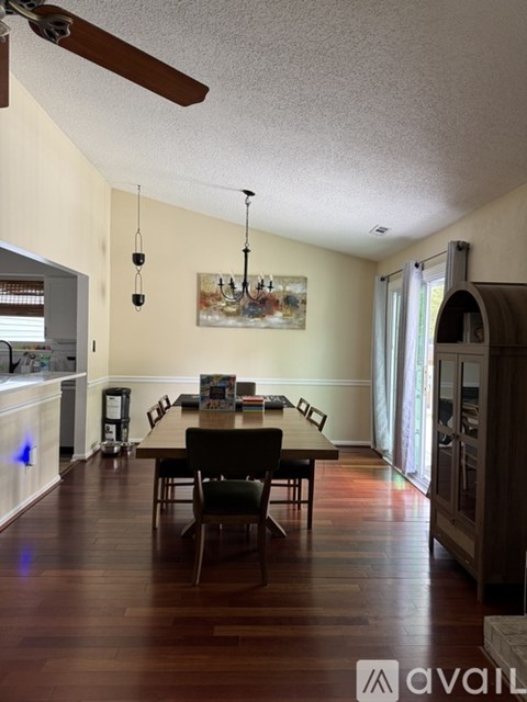 A dining room with a table and chairs.