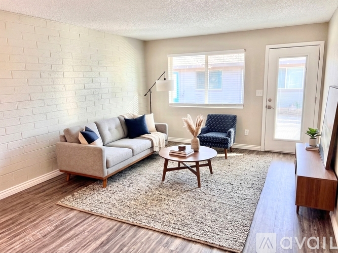 A living room with a grey couch, a wooden coffee table, and a rug.