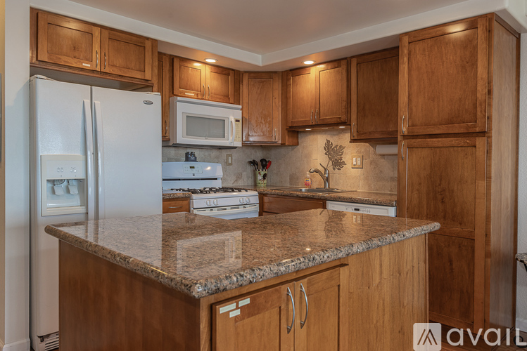 A kitchen with wooden cabinets and a granite countertop.