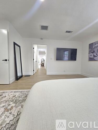 A bedroom with a large bed and a painting on the wall.