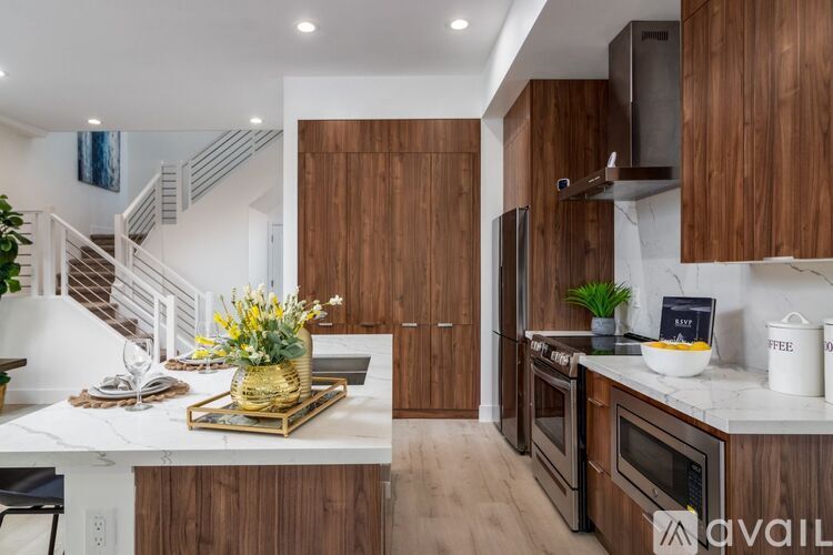 A kitchen with wooden cabinets and a marble countertop.