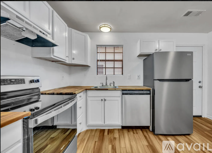 A modern kitchen with white cabinets and stainless steel appliances.