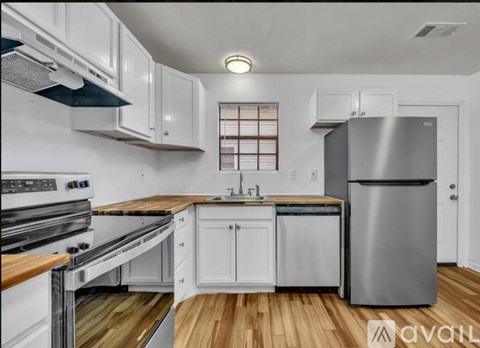 A modern kitchen with white cabinets and stainless steel appliances.