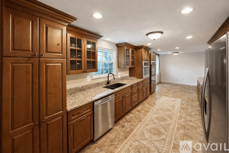 A kitchen with wooden cabinets and a granite countertop.