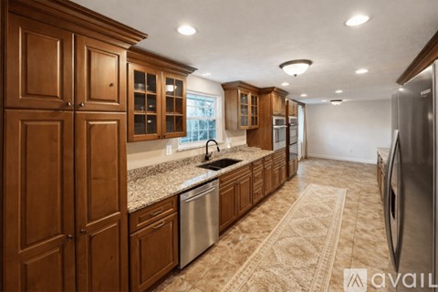 A kitchen with wooden cabinets and a granite countertop.