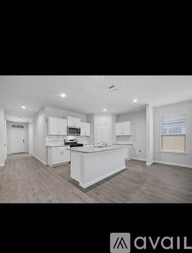 A modern kitchen with white cabinets and a central island.