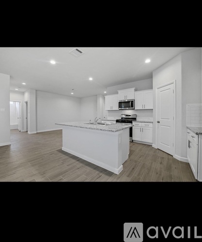 A modern kitchen with white cabinets and a central island.