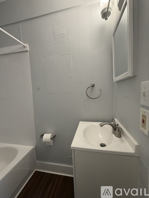 A bathroom with a white sink and a white bathtub.