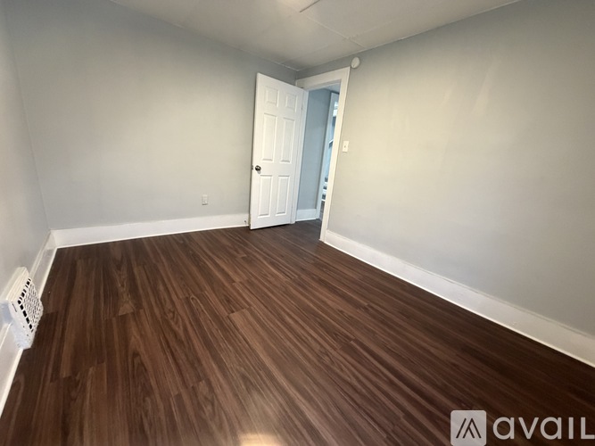 A room with wooden flooring and a white door.