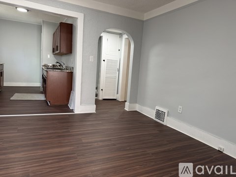 A room with wooden flooring and a white door.