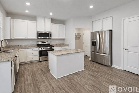 A kitchen with white cabinets and a stainless steel refrigerator.