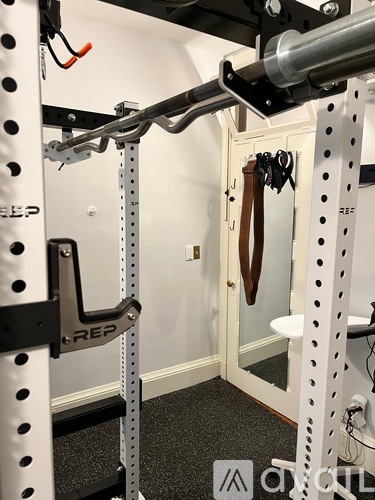 A gym with a squat rack and a mirror.