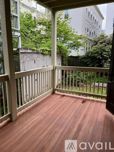 A wooden deck with a railing and trees in the background.