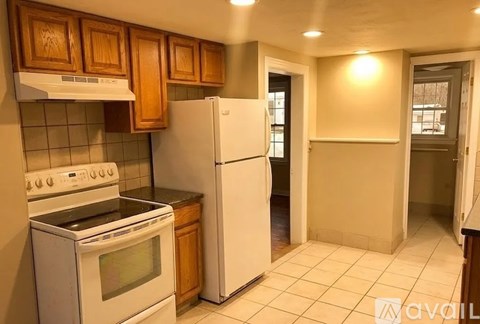 A kitchen with white appliances and wooden cabinets.