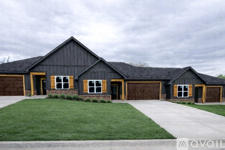 A house with a grey roof and brown garage doors.