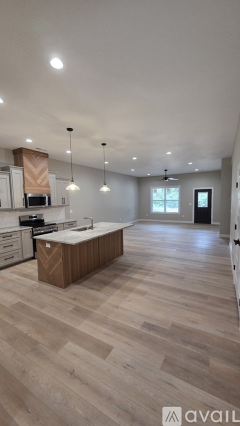 A kitchen with wooden floors and a large island in the middle.
