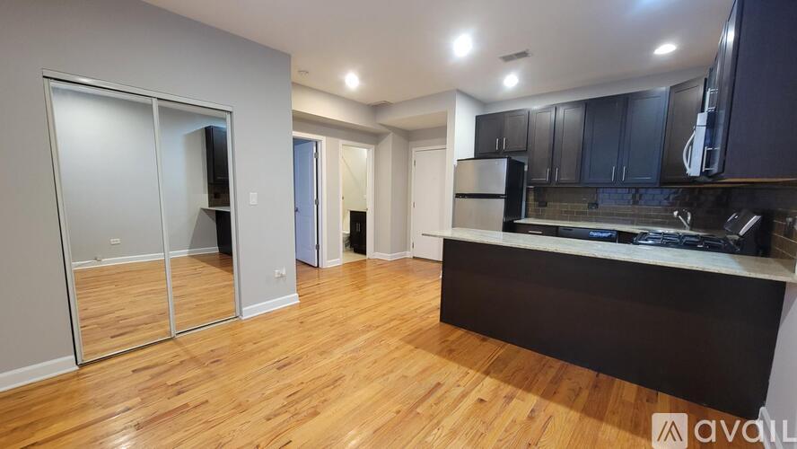 A kitchen with wooden floors and a black countertop.