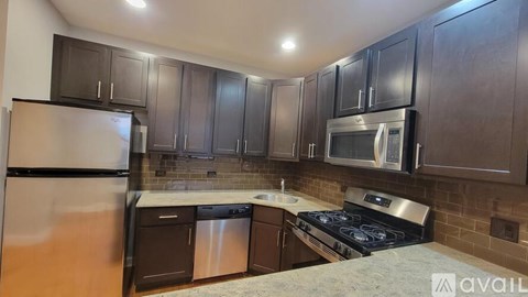 A kitchen with dark brown cabinets and stainless steel appliances.