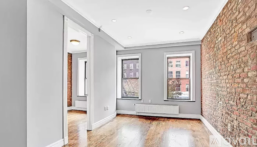 A room with a brick wall and a window.