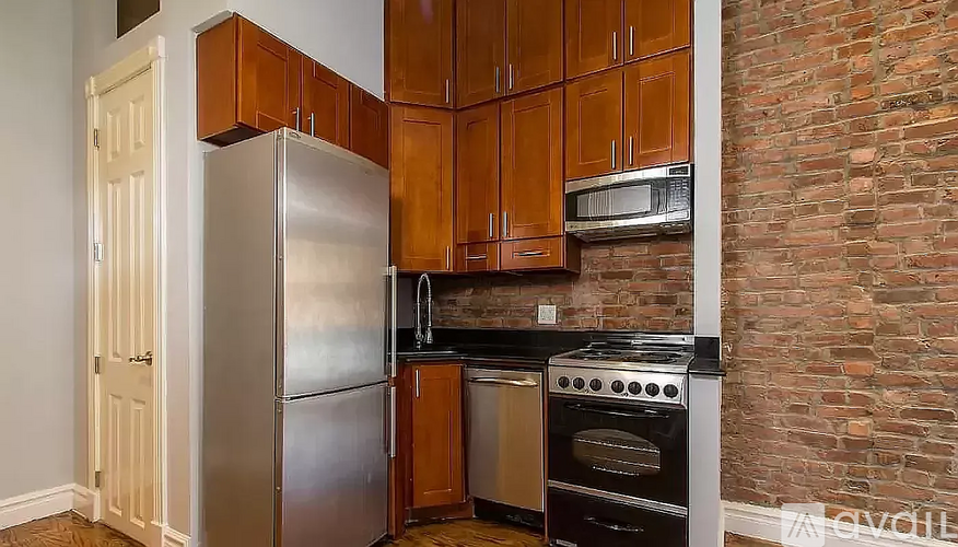 A kitchen with a stainless steel refrigerator, oven, and microwave.
