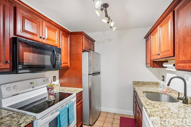 A kitchen with wooden cabinets and granite countertops.