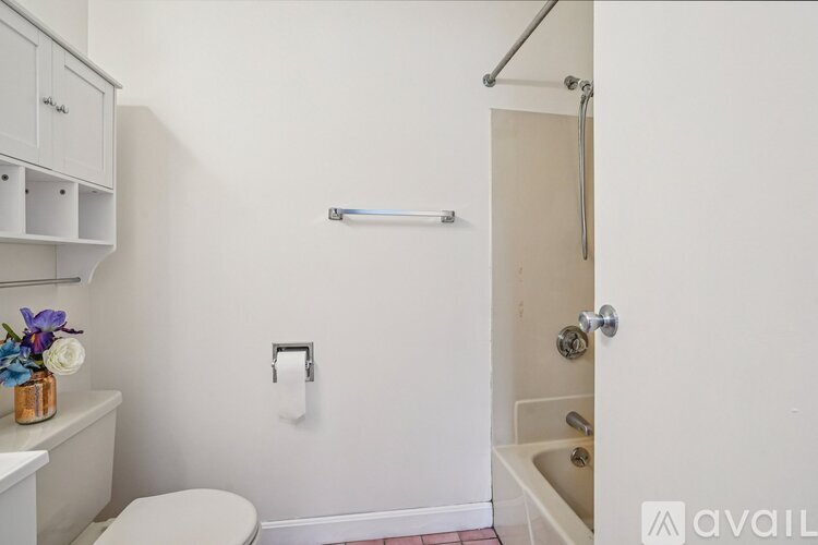 A white bathroom with a toilet, sink, and shower.