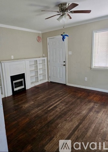 A room with a wood floor and a ceiling fan.
