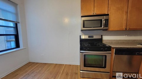 A kitchen with wooden cabinets and stainless steel appliances is available for rent.