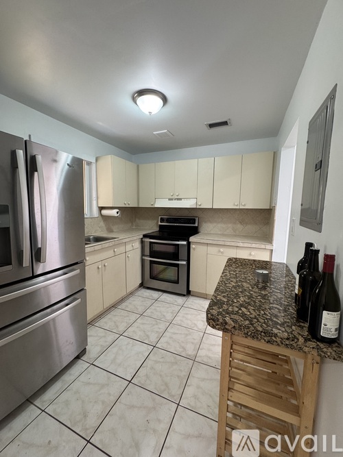 A kitchen with a granite countertop and stainless steel appliances.