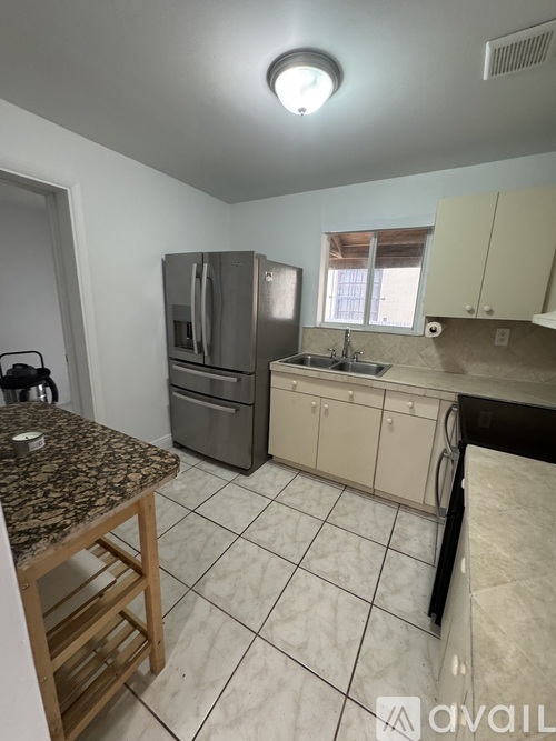 A kitchen with a granite countertop and stainless steel appliances.