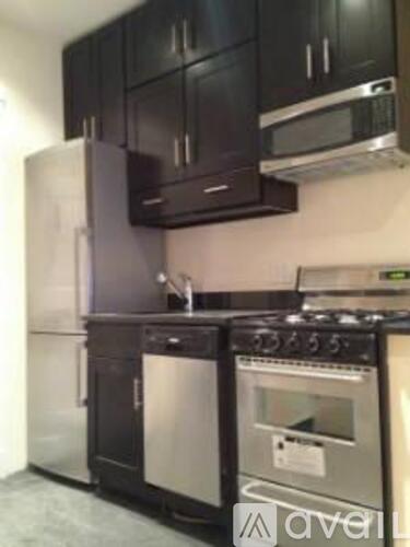 A kitchen with black cabinets and stainless steel appliances.