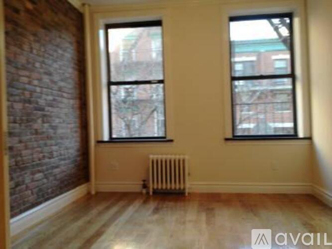 A room with a brick wall and a wooden floor.