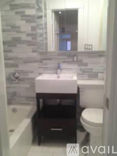 A bathroom with a toilet, sink, and mirror.