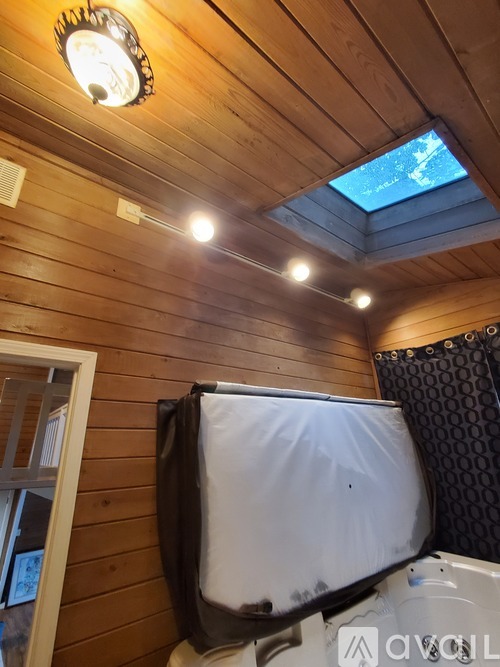 A small room with a skylight and a wooden ceiling.