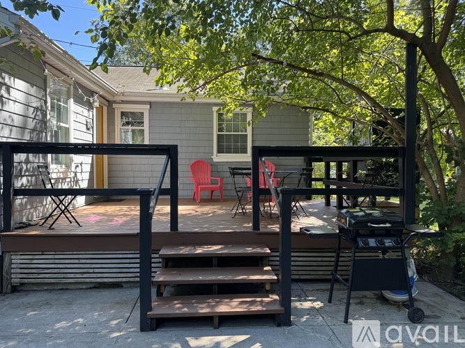 A patio with a table and chairs is surrounded by trees.