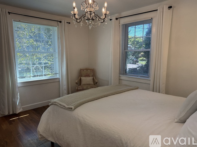 A bedroom with a large bed and a chandelier.