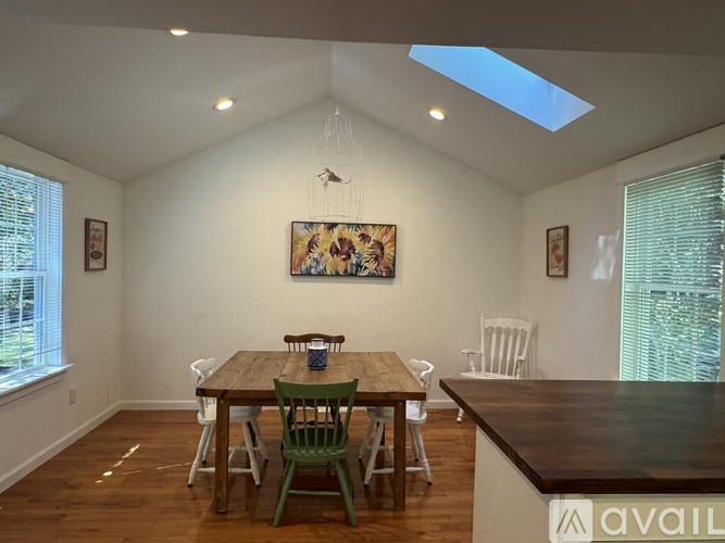 A dining room with a wooden table and chairs.
