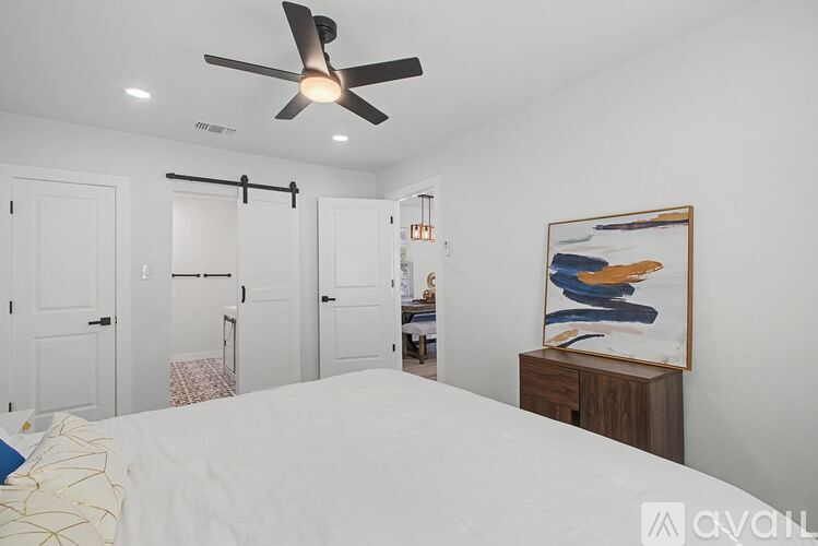 A bedroom with a large bed and a ceiling fan.