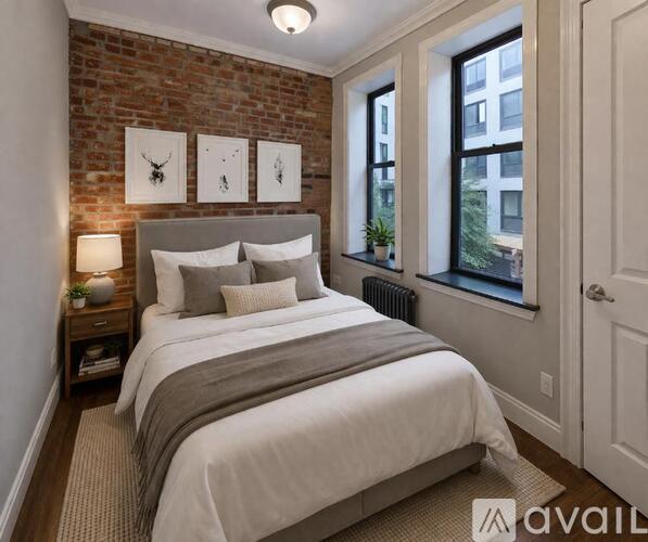 A bedroom with a brick wall and a large bed.