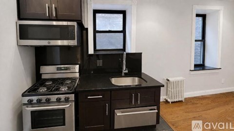 A kitchen with dark brown cabinets and stainless steel appliances.