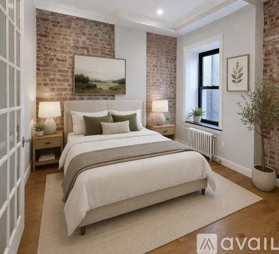 A bedroom with a large bed and a brick wall.