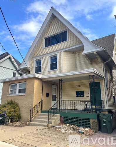 A two-story house with a garage door and a bicycle parked outside.