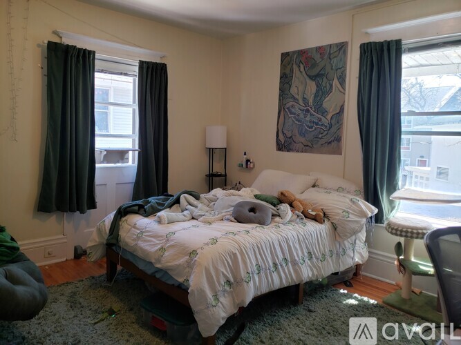A bedroom with a bed, a chair, and a painting on the wall.