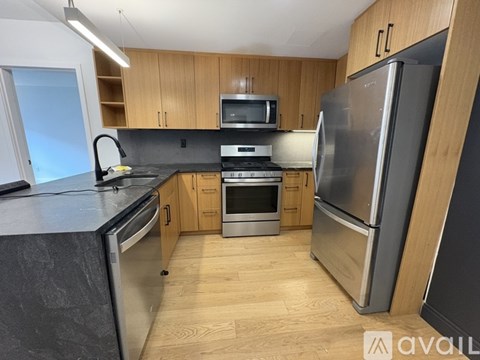 A kitchen with wooden cabinets and a black countertop.
