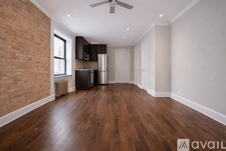 A room with wooden floors and a brick wall.