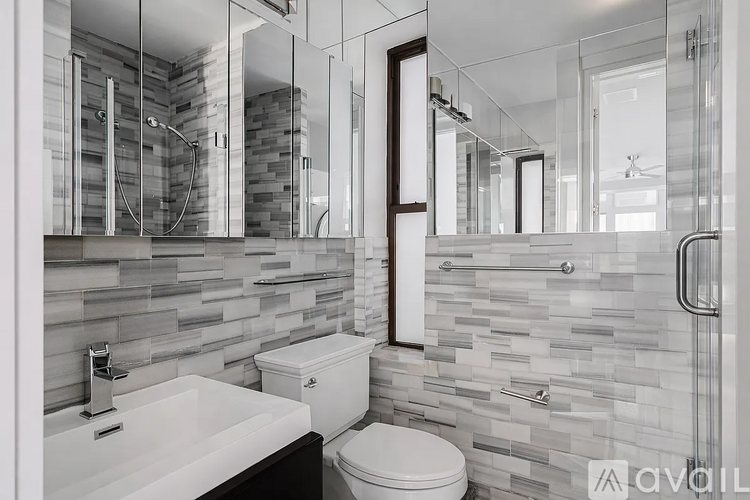 A bathroom with a toilet, sink, and a glass shower stall.
