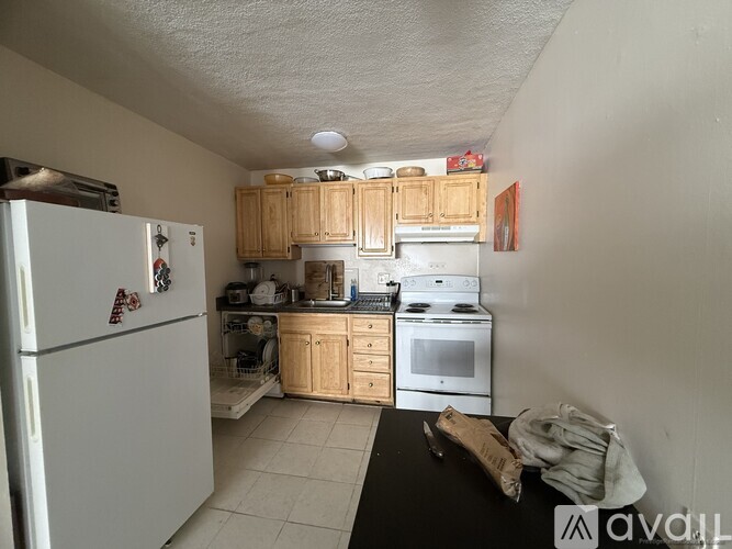 A kitchen with white appliances and wooden cabinets.