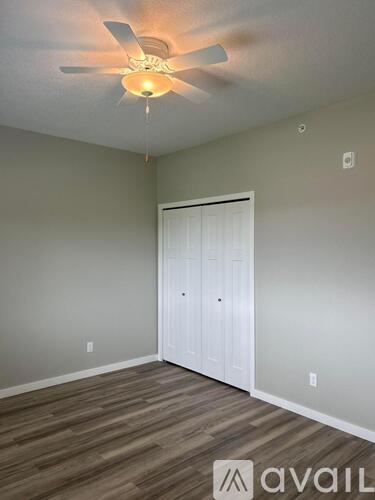A room with a ceiling fan and a door.